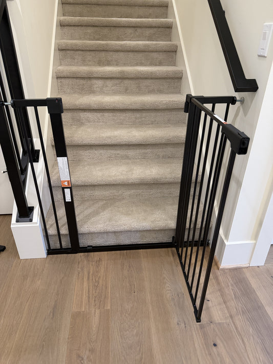 Professional handyman installing a white hardware-mounted baby gate at the top of a staircase in a modern home, natural light, photorealistic, no text, Pacific Northwest interior style