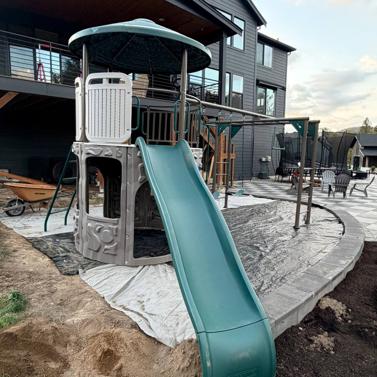 Adventure Tower Deluxe playset with green wave slide assembled in a Bothell backyard
