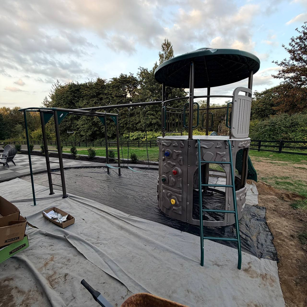 Finished Lifetime Adventure Tower Deluxe metal playset installed on weed barrier with paver border