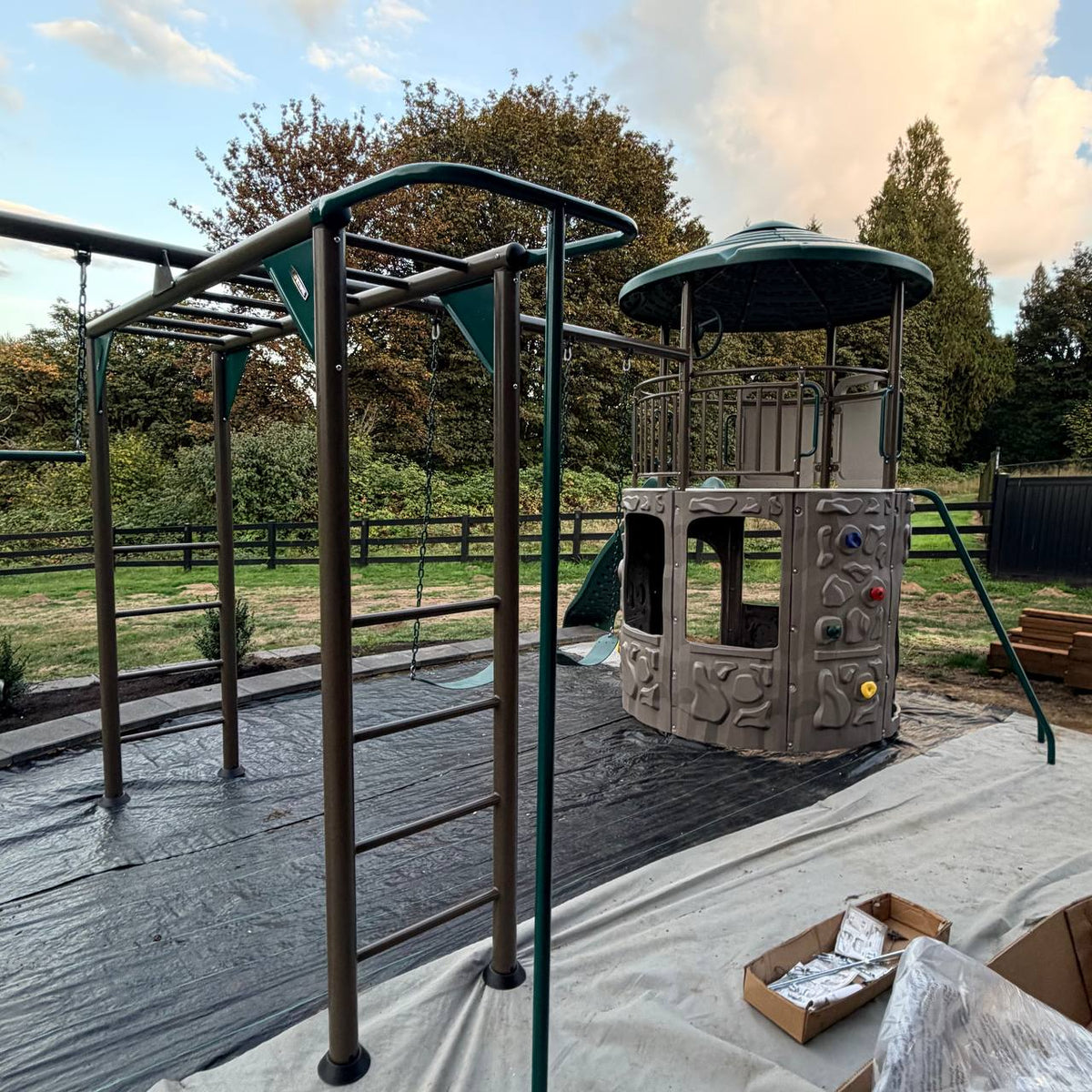 Metal swing set and monkey bars installed beside the Adventure Tower Deluxe play structure