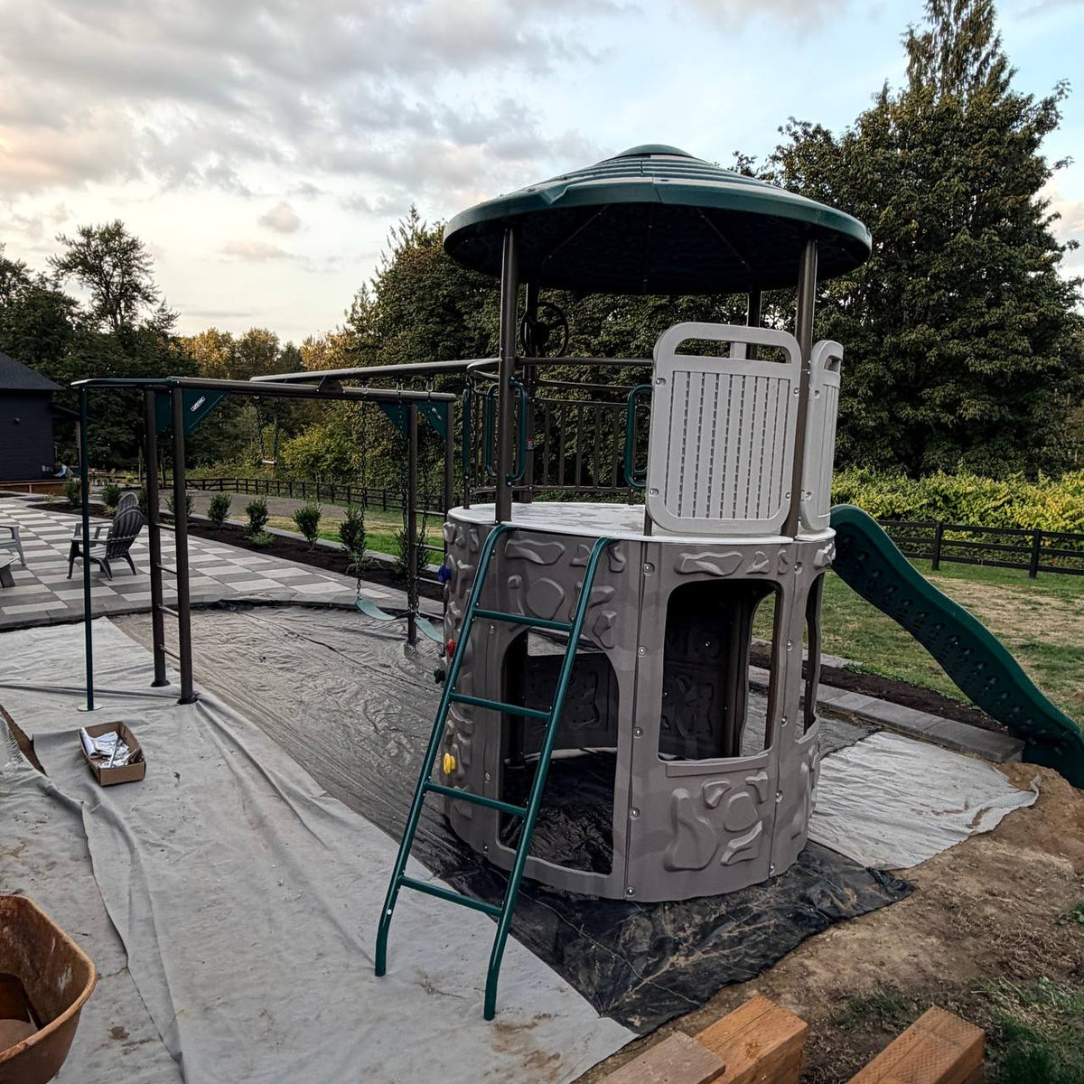 Metal swing set and monkey bars installed beside the Adventure Tower Deluxe play structure