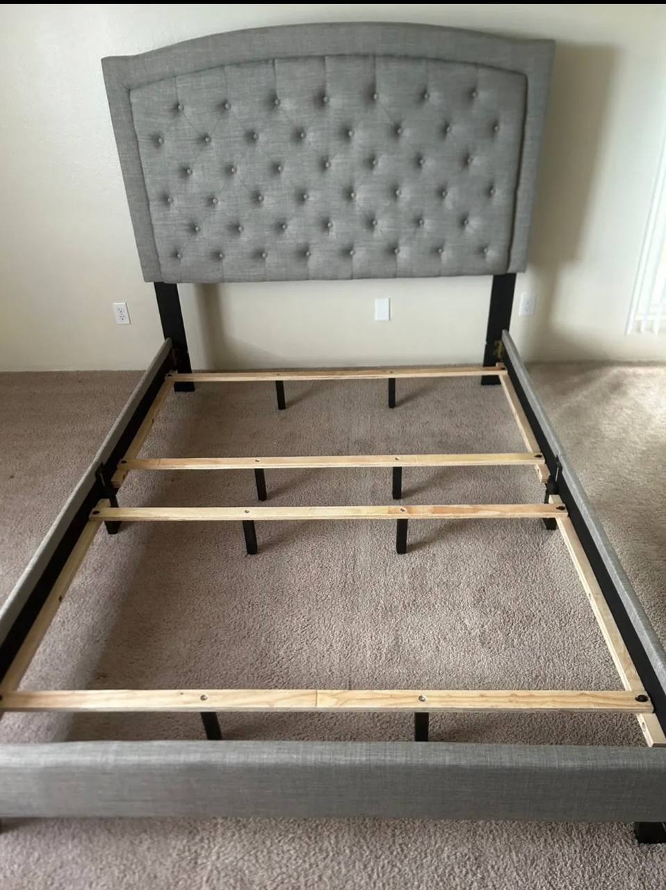 Gray tufted upholstered queen bed frame assembly with wood slats