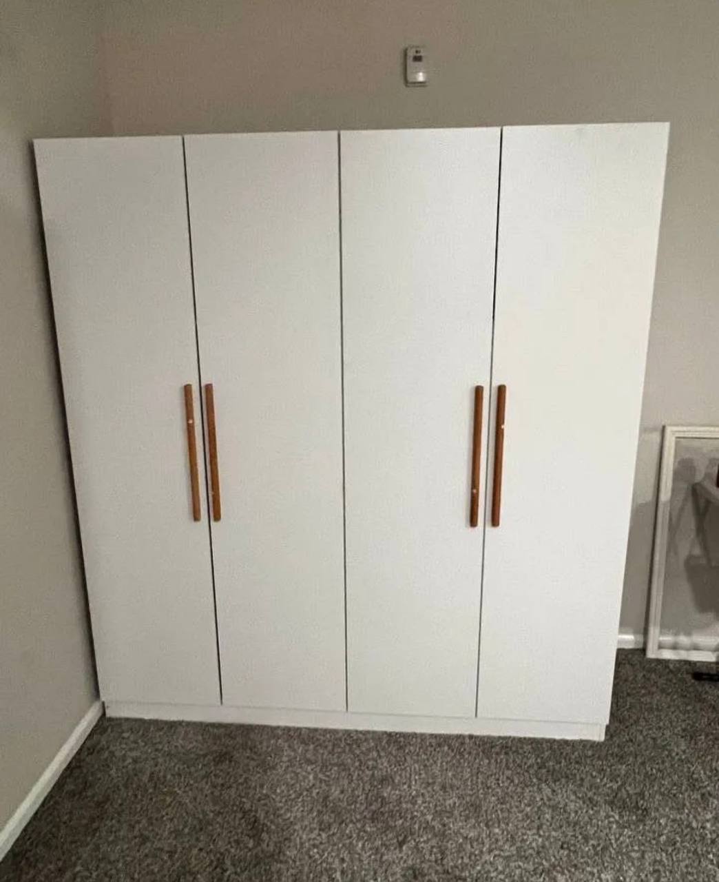 White 4-door wardrobe with wood handles assembled by 24 Solve in Bothell