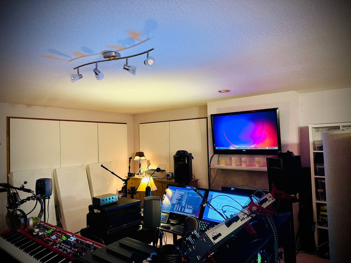 Suspended acoustic ceiling cloud installed above studio monitors